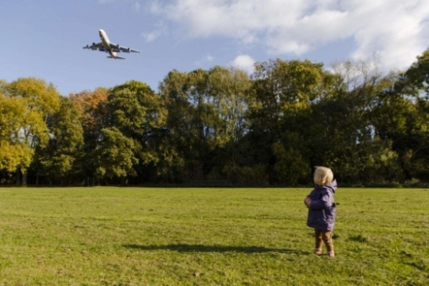 foto met kind in park en vliegtuig hoog overvliegend